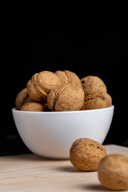 istock Walnuts in a white bowl on a wooden table 1415922389