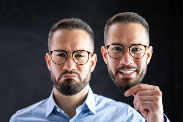 Family relationships concept. Silhouetted portrait of two young caucasian twin brothers looking at each other while standing face to face isolated over white background