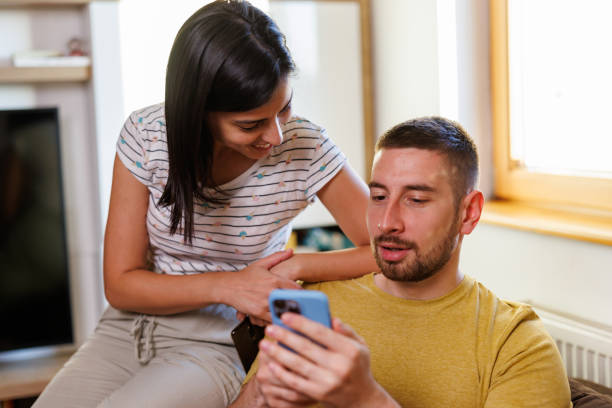 istock Young couple using a phone at home 1415930258
