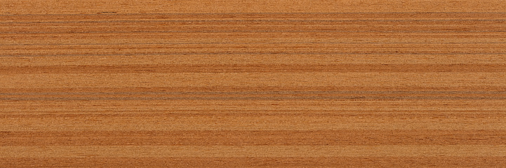 High angle view of a flat textured wooden board backgrounds. It has a beautiful nature and abstractive pattern. A close-up studio shooting shows details and lots of wood grain on the wood table. The piece of wood at the surface of the table also appears rich wooden material on it. The wood is dark brown color with darker brown lines and pattern on the bottom. Flat lay style. Its high-resolution textured quality.