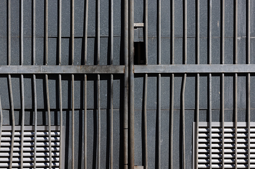 Metal gate in front of a gray door.