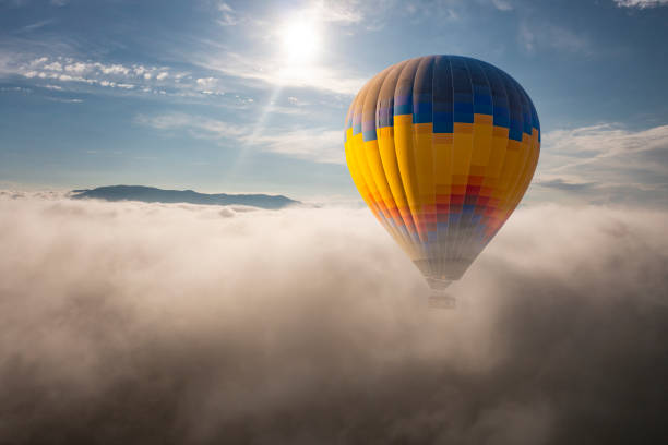 istock Colorful hot air balloon flying above the clouds. 1415935154