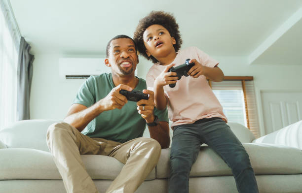 istock African Father and son playing console games 1415937250