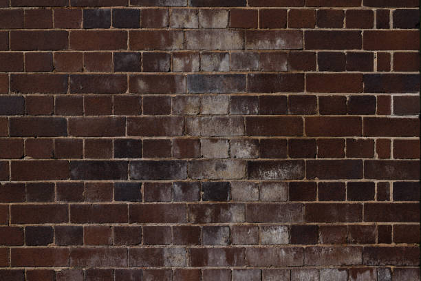 istock Old dirty dark brown brick wall 1415942290