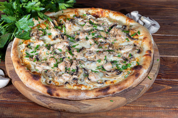 istock Pizza with bacon and cheese, herbs and cherry tomatoes. With mozzarella, shrimp and octopus, mussels and other products on a wooden background. 1415944167
