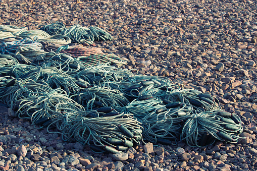 rope used in the fishing industry in neat coils on a stone beach