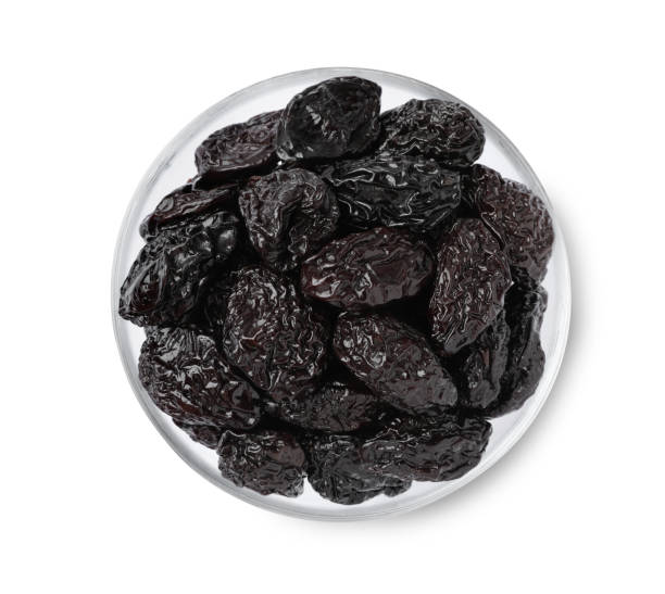 istock Bowl with sweet dried prunes isolated on white, top view 1415945628