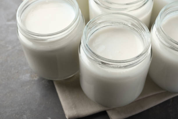 istock Tasty yogurt in glass jars on grey table, closeup 1415946814