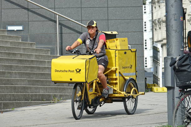 vélo cargo transportant du courrier - messenger deutsche post ag package germany photos et images de collection