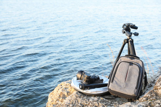 istock Professional photography equipment on rocky river coast 1415947691