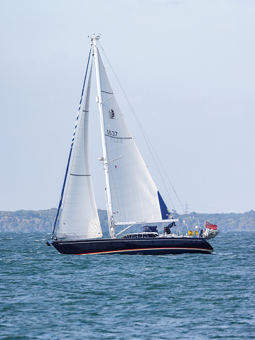 August 2022, Isle of Wight, UK. Pleasure craft yacht Blue Harmony makes its way past Newtown Creek on the solent.