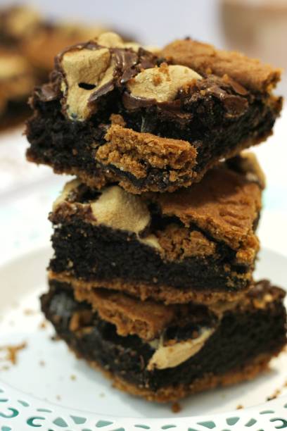 istock stack of sliced biscoff s'mores brownies. chocolate cake topped with biscoff  biscuits and marshmallow on a white plate. 1415949562