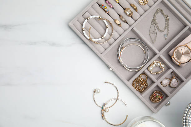 istock Elegant jewelry box with beautiful bijouterie on white marble table, flat lay. Space for text 1415950196