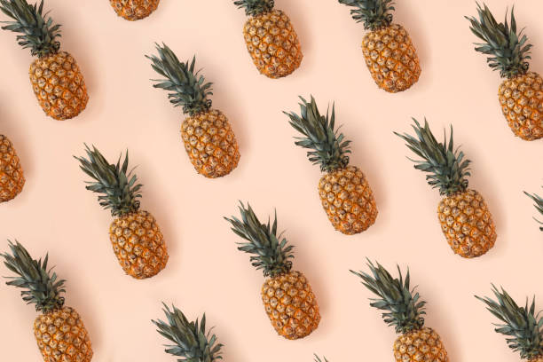 istock Bright pattern of many pineapples on a trendy soft beige pink background 1415951953