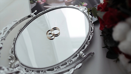 Beautiful wedding rings on a vintage mirror. wedding rings on the mirror surface.