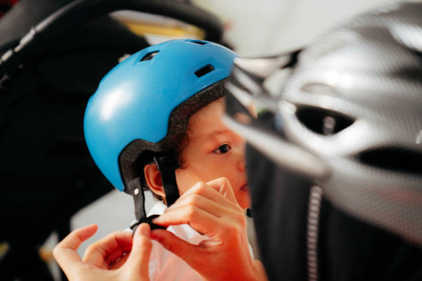 Mother putting a helmet on her son's head