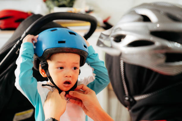 istock Mother putting a helmet on her son's head 1415954893