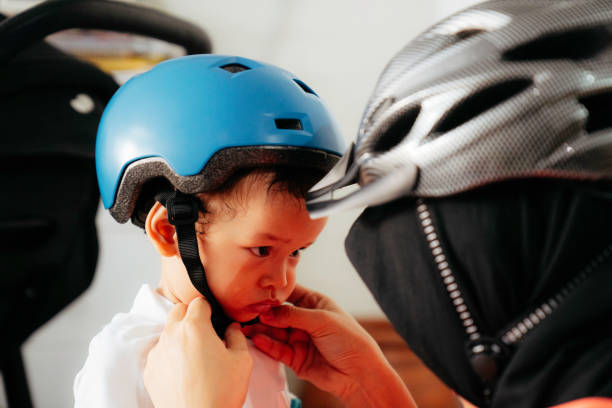 istock Mother putting a helmet on her son's head 1415954894