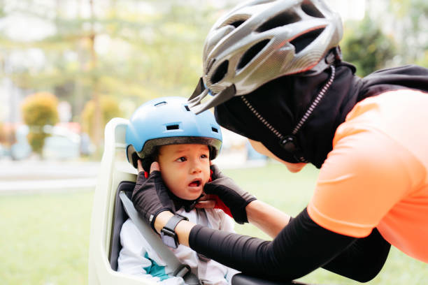istock Mother putting a helmet on her son's head 1415954911
