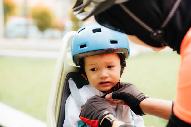 istock Mother putting a helmet on her son's head - 1415954937