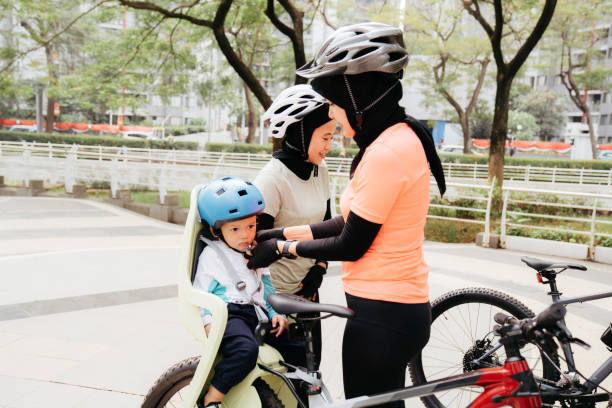 istock Mother putting a helmet on her son's head when her friend watching them 1415955246