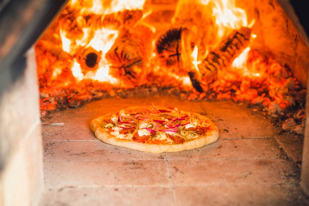 istock Pizza with toppings in a hot stone oven 1415955723