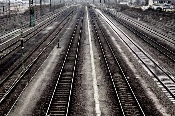 The parallel tracks of a railway line in black and white