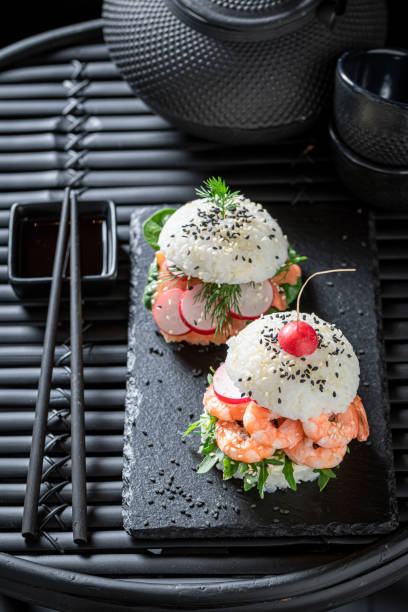 istock Exquisite sushi burger with vegetables and seafood on strone plate. 1415956775