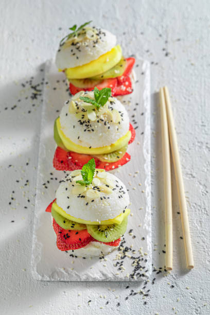 istock Tasty sushi burger with strawberries and mango on white plate. 1415957585