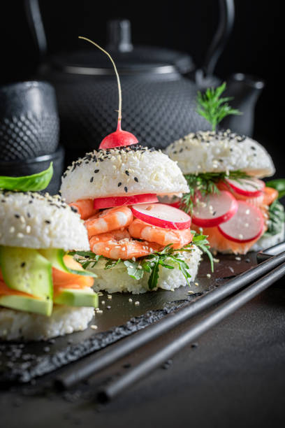 istock Unique sushi burger with vegetables and seafood on strone plate. 1415957667