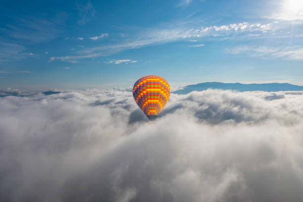 istock Colorful hot air balloon flying above the clouds. 1415958882