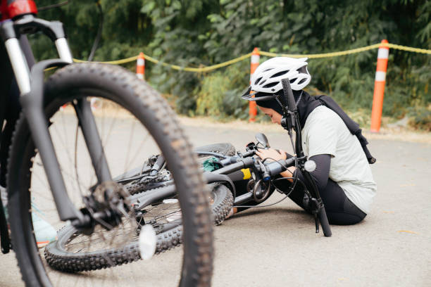 mulher muçulmana ajudando seu amigo a se levantar depois de cair de uma bicicleta. - acidente evento relacionado com o transporte - fotografias e filmes do acervo