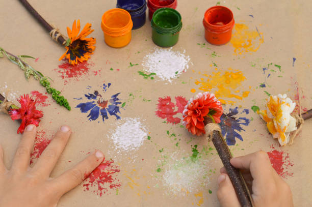 zbliżenie dziecięcych dłoni, które tworzą rysunek za pomocą kwiatu, szturchając. co zrobić z dziećmi w przedszkolu lub obozie szkolnym w lecie. - craft zdjęcia i obrazy z banku zdjęć