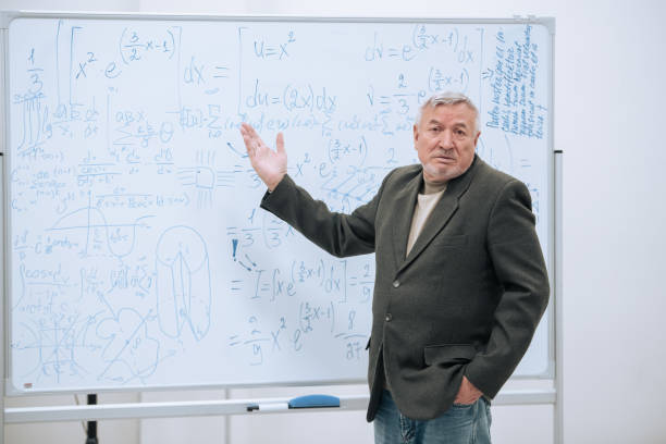 istock An elderly professor of mathematics stands in his office at a white board with notes and explains the material to students 1415960573