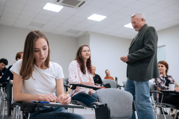 istock An elderly teacher at a technical university conducts a lecture for first-year students in the college auditorium 1415961049