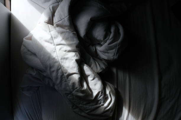 istock Messy bed sheet, underexposed photo 1415961084