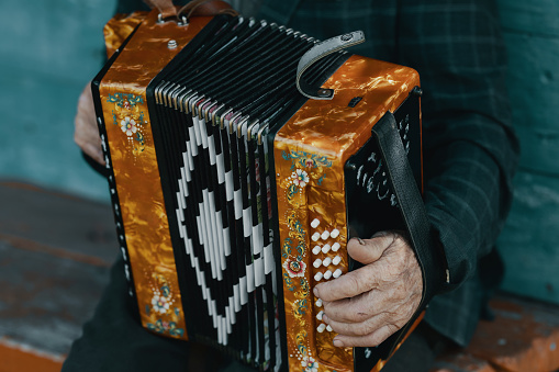 Elderly man plays a Russian accordion close-up. Kazan, Russia — June 12, 2022