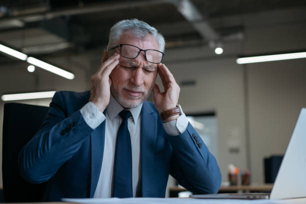 istock Tired stressed businessman having headache sitting in office. Overwork concept 1415964124