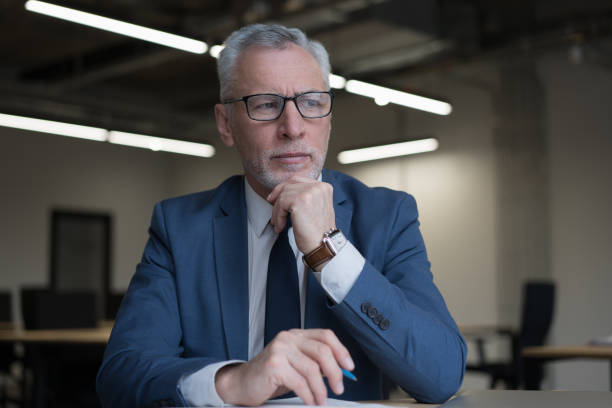 istock Serious senior businessman planning project, thinking, looking away working in office 1415964202