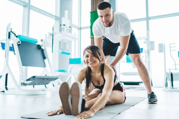 istock Cheerful woman exercising with instructor 1415965770