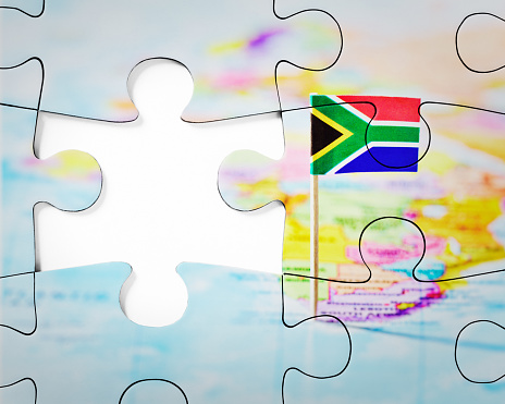 Representing problems and solutions, a jigsaw puzzle of the flag of South Africa with a gap for the last missing piece.