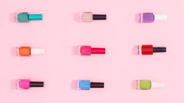 istock Nail polish bottles in various colors  make patern on pastel pink background. Flat lay 1415967682