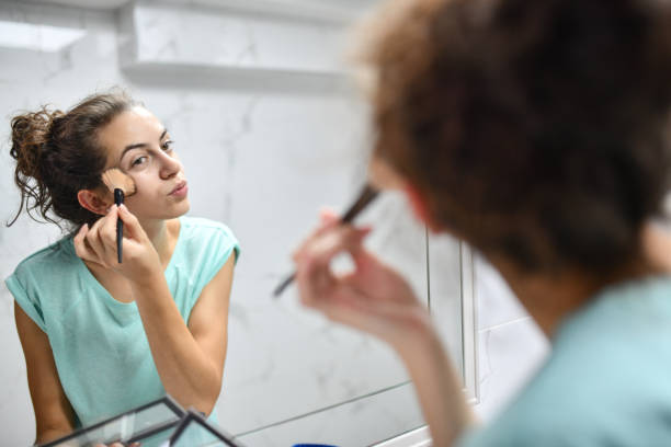 istock Focused Female Putting Powder In Bathroom While Preparing For Going Out 1415969494