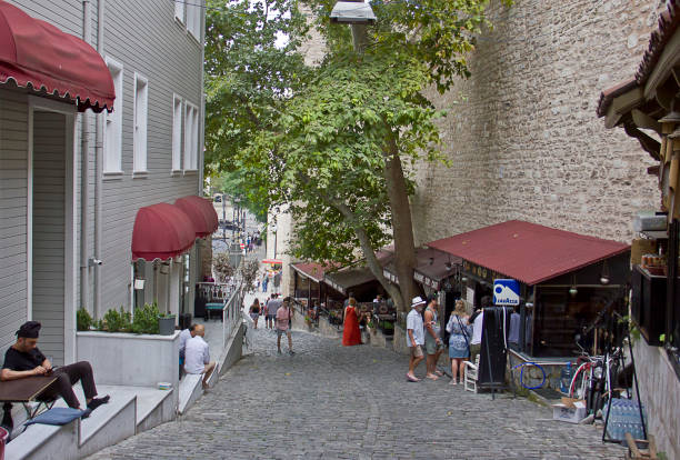 Istanbul,Turkey - August 10, 2022: Street view with people walking at sultanahmet district to gülhane and sirkeci in the Fatih district of Istanbul. There are old colorful houses and mosques during the street. The area contain Hagia sophia mosque, sultanahmet mosque and topkapı palace.