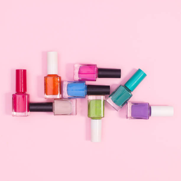 istock Creative composition of nail polish bottles in various colors on pastel pink background. Flat lay 1415970130