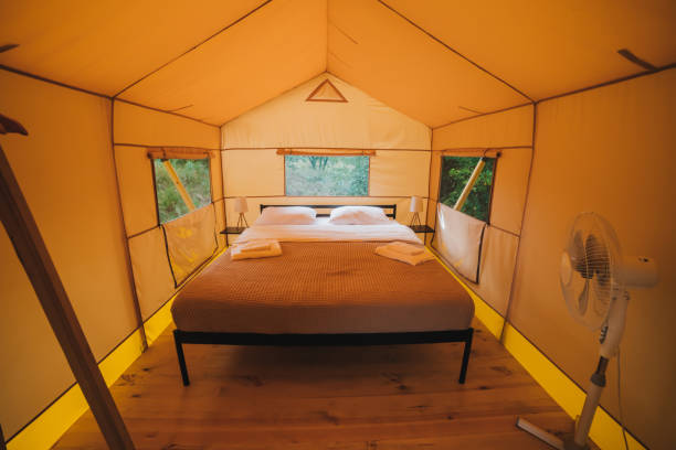 istock Interior of Cozy open glamping tent with light inside during dusk. Luxury camping tent for outdoor summer holiday and vacation. Lifestyle concept 1415971185