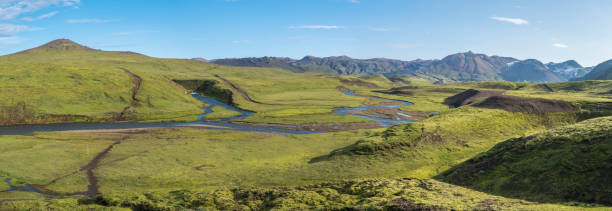 Panoramic landscape with blue river stream, green hills, snow-capped mountains, meadow and lush moss. Laugavegur hiking trail. with Fjallabak Nature Reserve, Iceland. Summer blue sky Panoramic landscape with blue river stream, green hills, snow-capped mountains, meadow and lush moss. Laugavegur hiking trail. with Fjallabak Nature Reserve, Iceland. Summer blue sky. ford crossing stock pictures, royalty-free photos & images