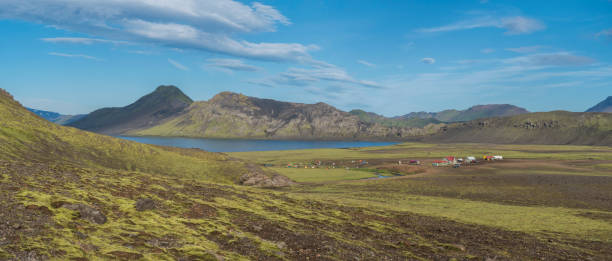 istock Panoramic landscape with mountain huts at camping site on blue Alftavatn lake with river, green hills and glacier in beautiful landscape of the Fjallabak Nature Reserve in the Highlands of Iceland part of Laugavegur hiking trail. 1415975332