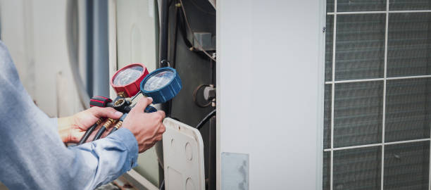 istock Mechanic  air conditioner technician is using a manifold gauge to check the refrigerant in the system to inspect and repair the outdoor air compressor. 1415976335