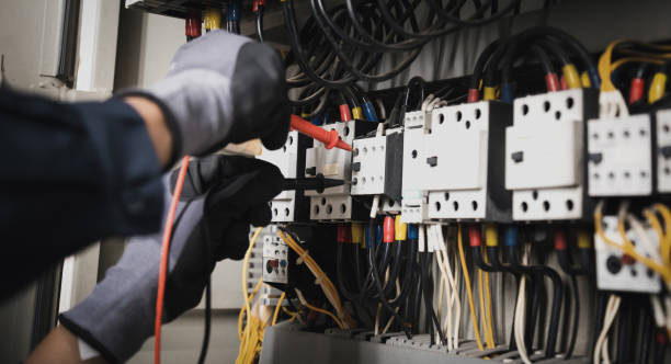 istock Electricity and electrical maintenance service, Engineer hand holding AC multimeter checking electric current voltage at circuit breaker terminal and cable wiring main power distribution board. 1415976599